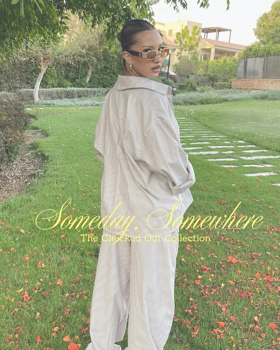 Model wearing a beige striped oversized shirt and matching trousers from the Checked Out collection